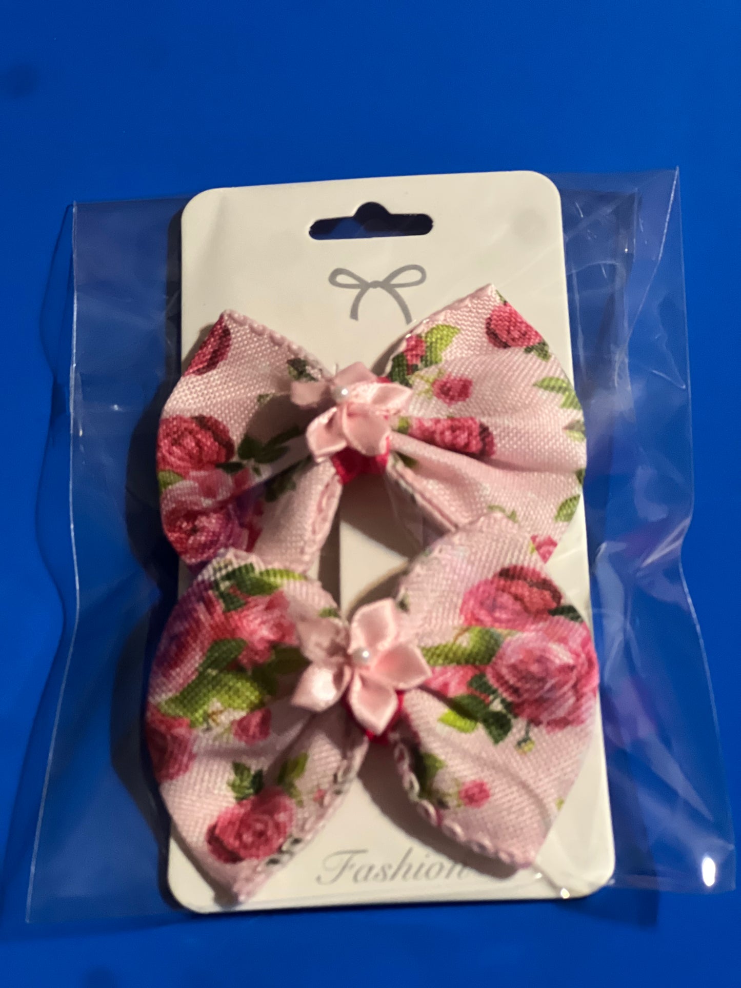Light pink hair bow with light pink ribbon flower in the center.