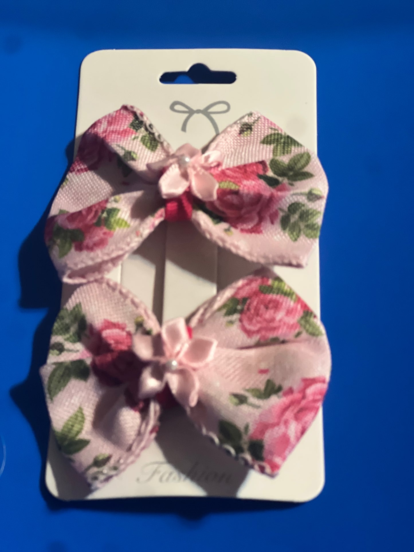 Light pink hair bow with light pink ribbon flower in the center.