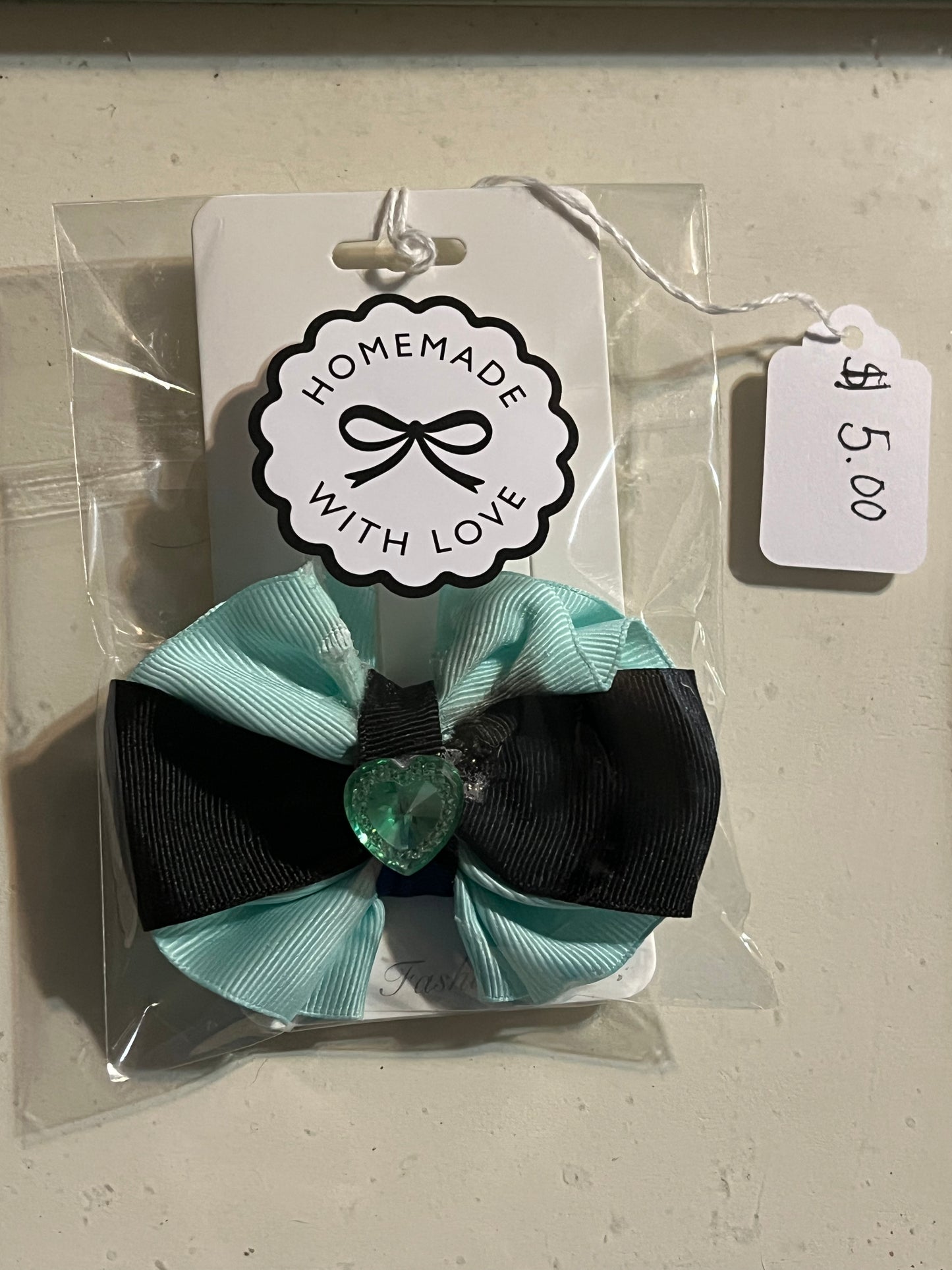 Light green and black hair bow with green heart.